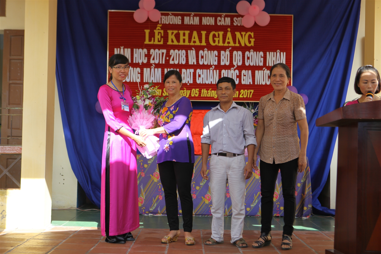 Đại diện Hội cha mẹ phụ huynh học sinh tặng hoa chúc mừng nhà trường